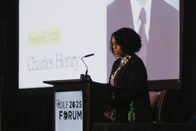 Two attendees smiling and talking near the conference area