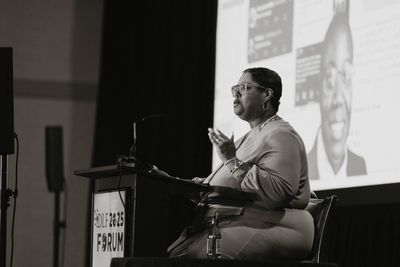 Attendees seated in a large session room facing the stage