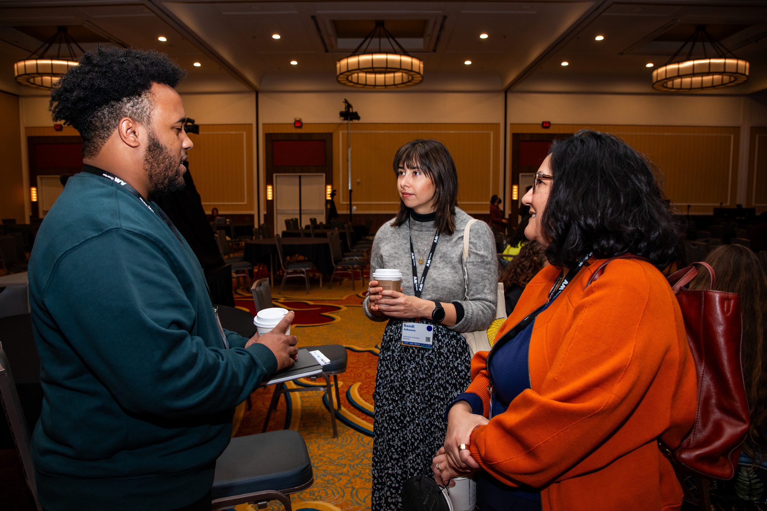 Three people standing and talking.