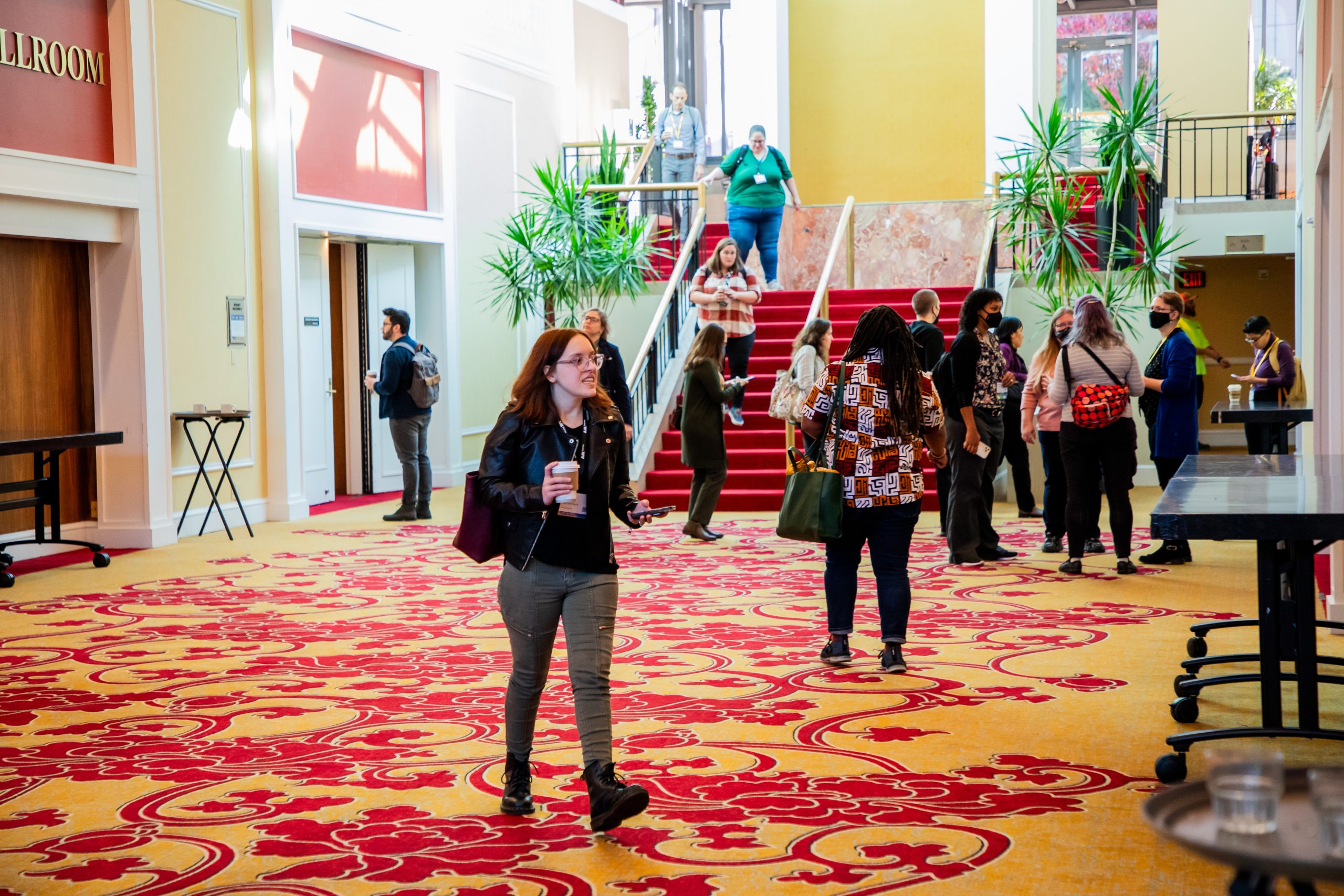 Hallway of conference area of hotel with people walking toward and away from the camera.